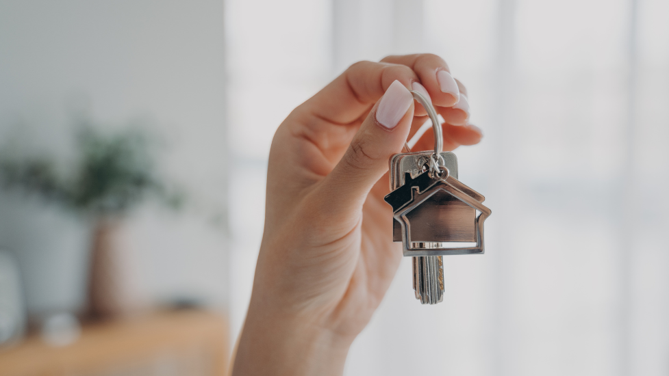 a hand holding a set of keys with house-shaped keychains