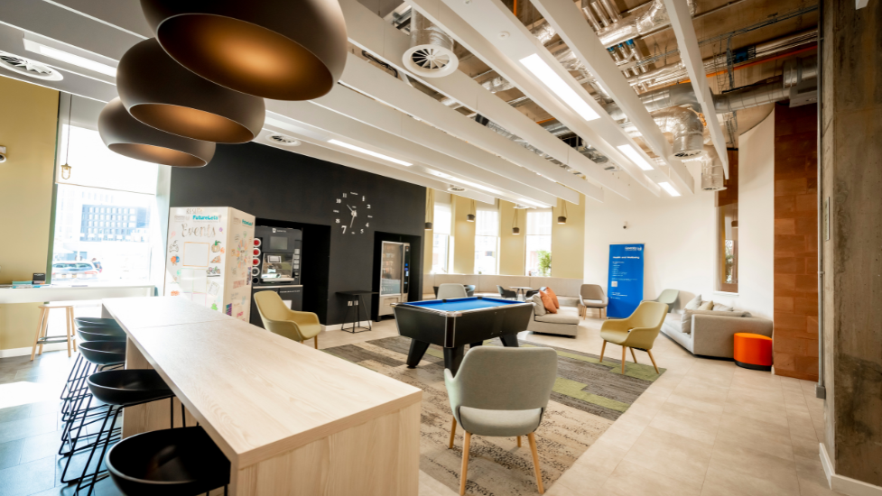 A social space in student accommodation with chairs, sofas and a pool table.