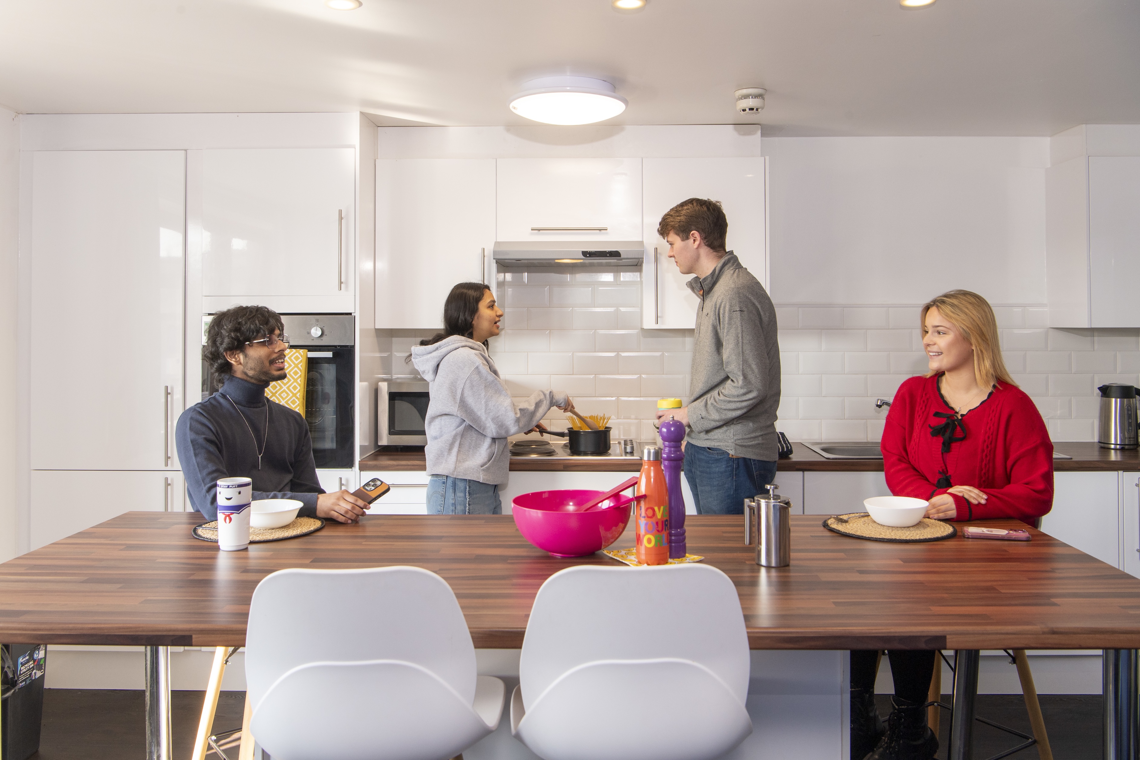 A group of people sitting at a Queen Margaret kitchen table