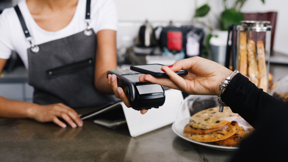 a person paying for food in a cafe