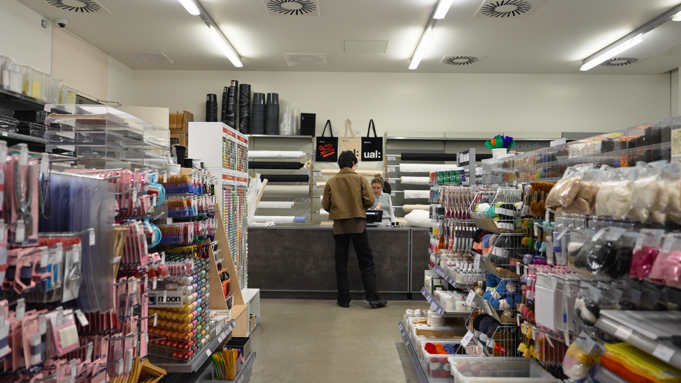 a shop filled with products, with a person being served at the counter