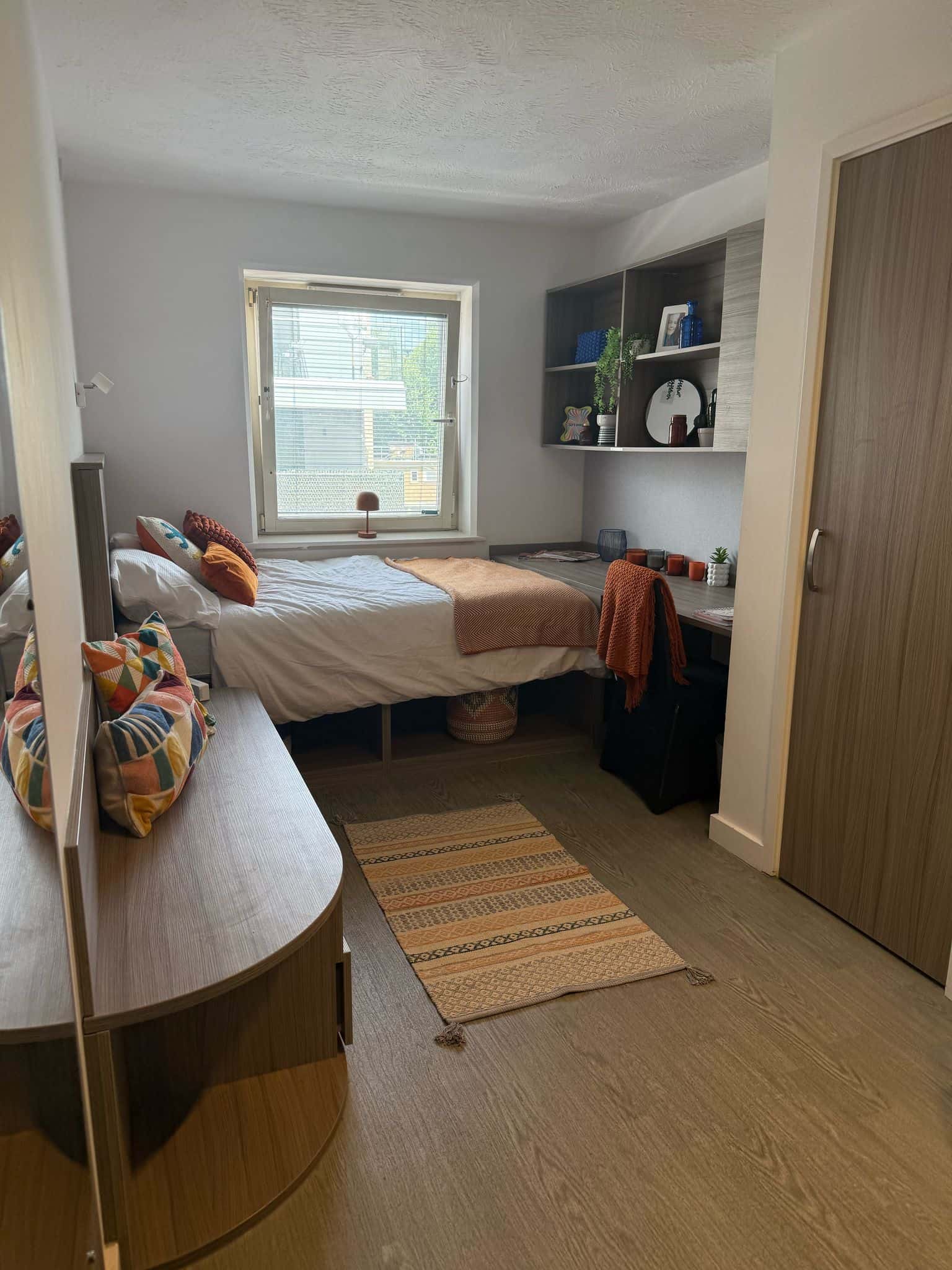 a bedroom with a bed and desk in a room