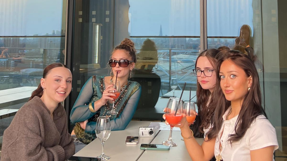 A group og women drinking cocktails on East Bank terrace.