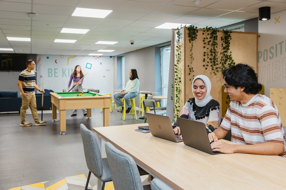 Karishma Lakhani et al. sitting at a table using a laptop