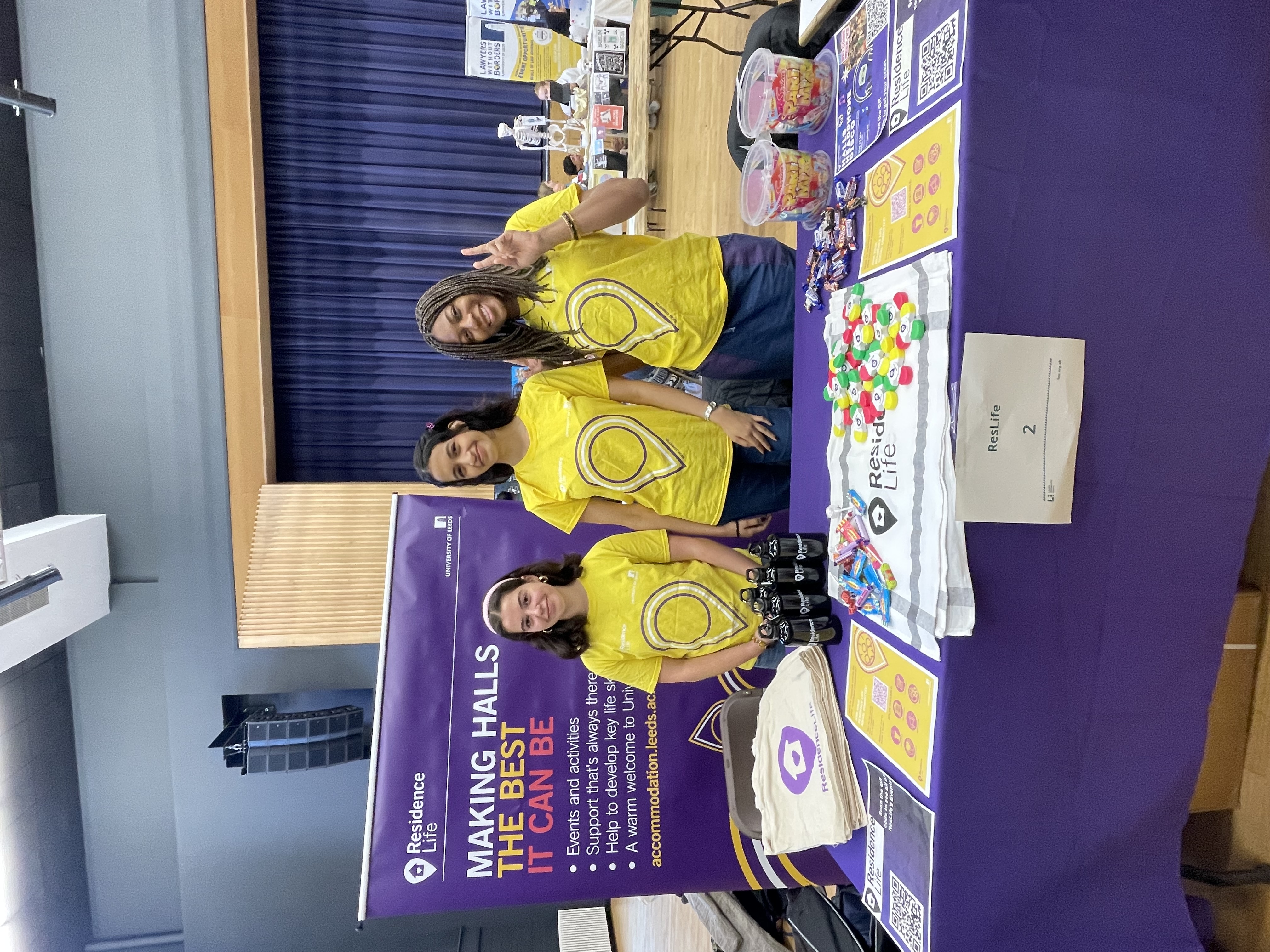 a group of event assistants at a stand promoting Residence Life