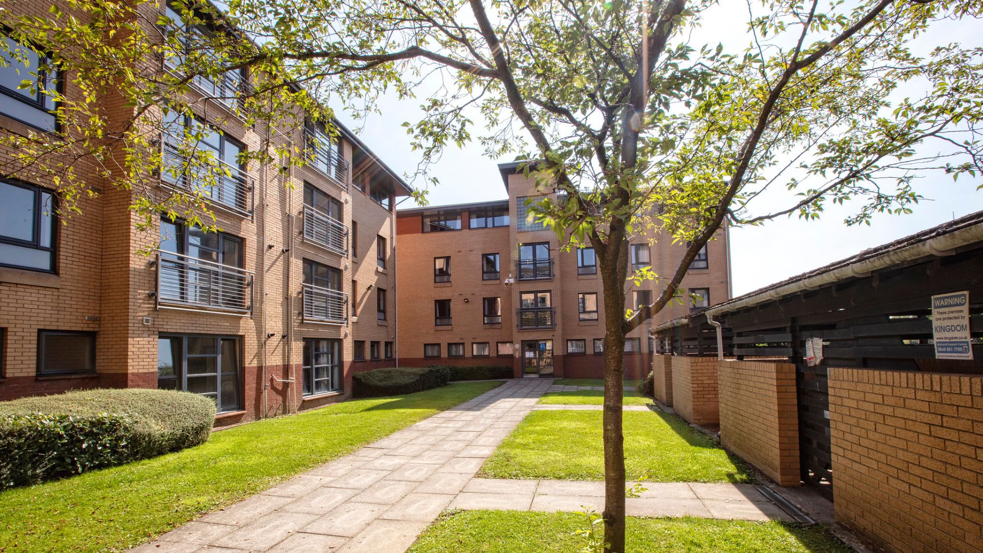 a large brick building with grass and trees